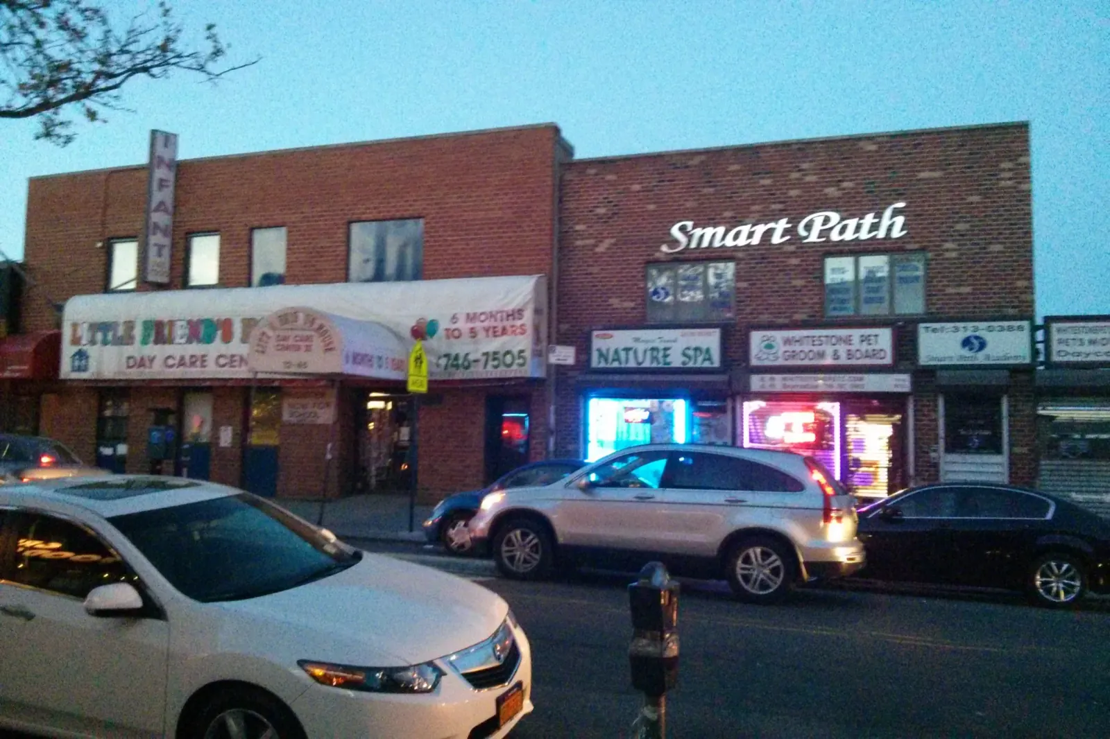A row of brick neighborhood storefronts in Whitestone.
