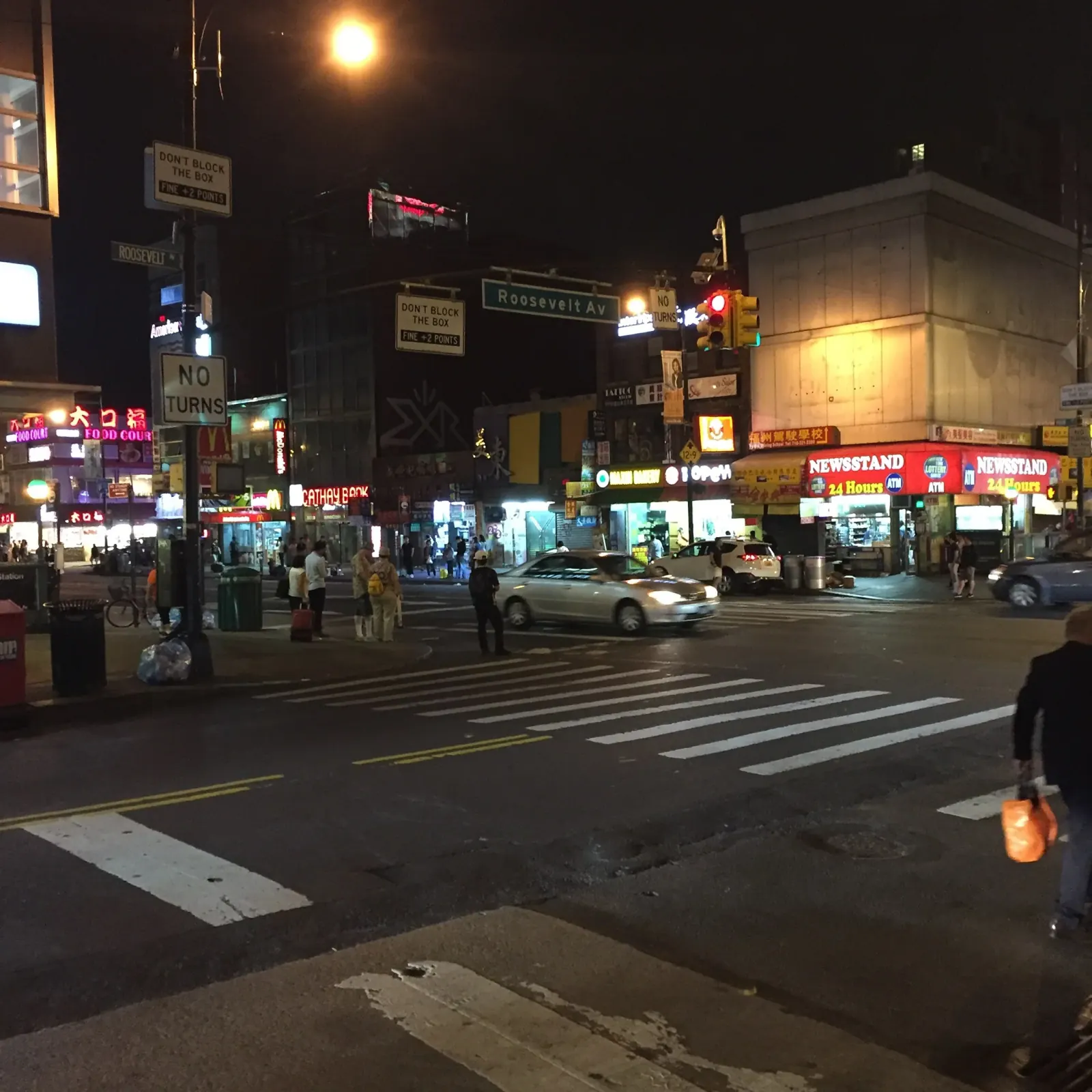 The intersection of Main Street and Roosevelt Avenue at night.