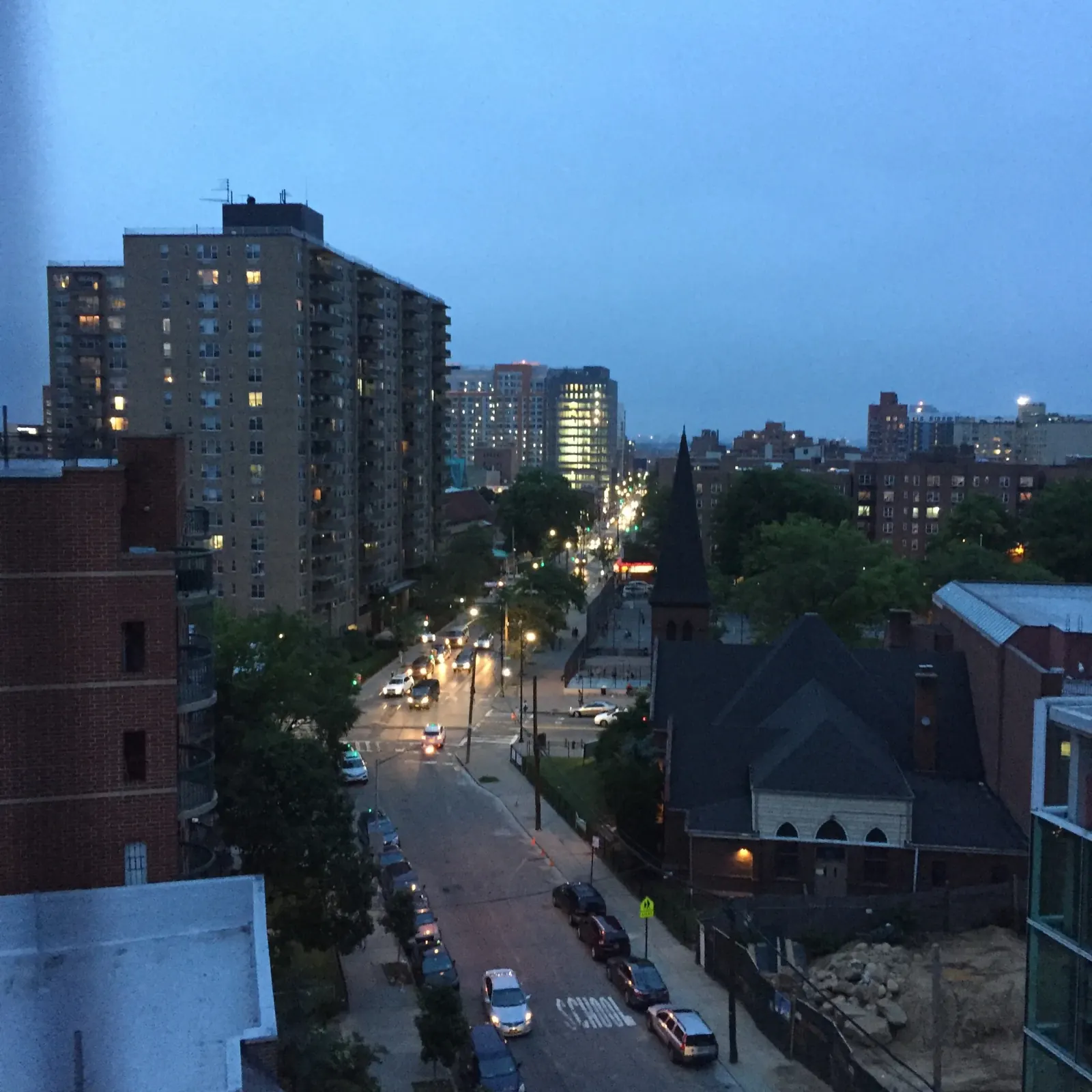 East Flushing rooftops and a neighborhood street at blue hour.